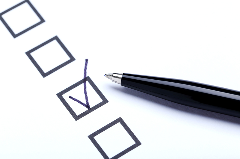 A black pen rests next to a series of tick boxes, in one of which is a checkmark